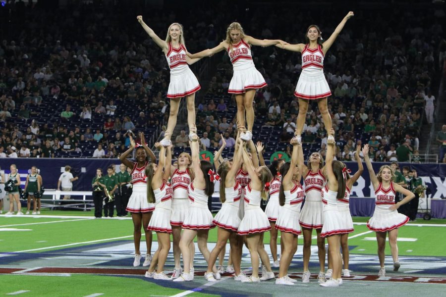The cheerleaders cheer at halftime with their magnificent tricks and flips.