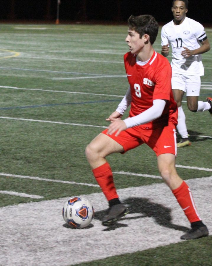 Alex Rivero 20 moves the ball forward in a late season game against St. Pius X.